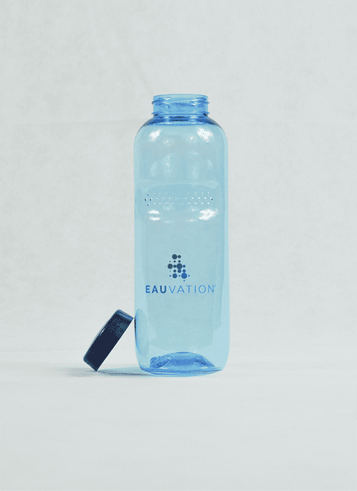 Eine blaue Eauvation TITRIN Flasche stehend auf dem Tisch